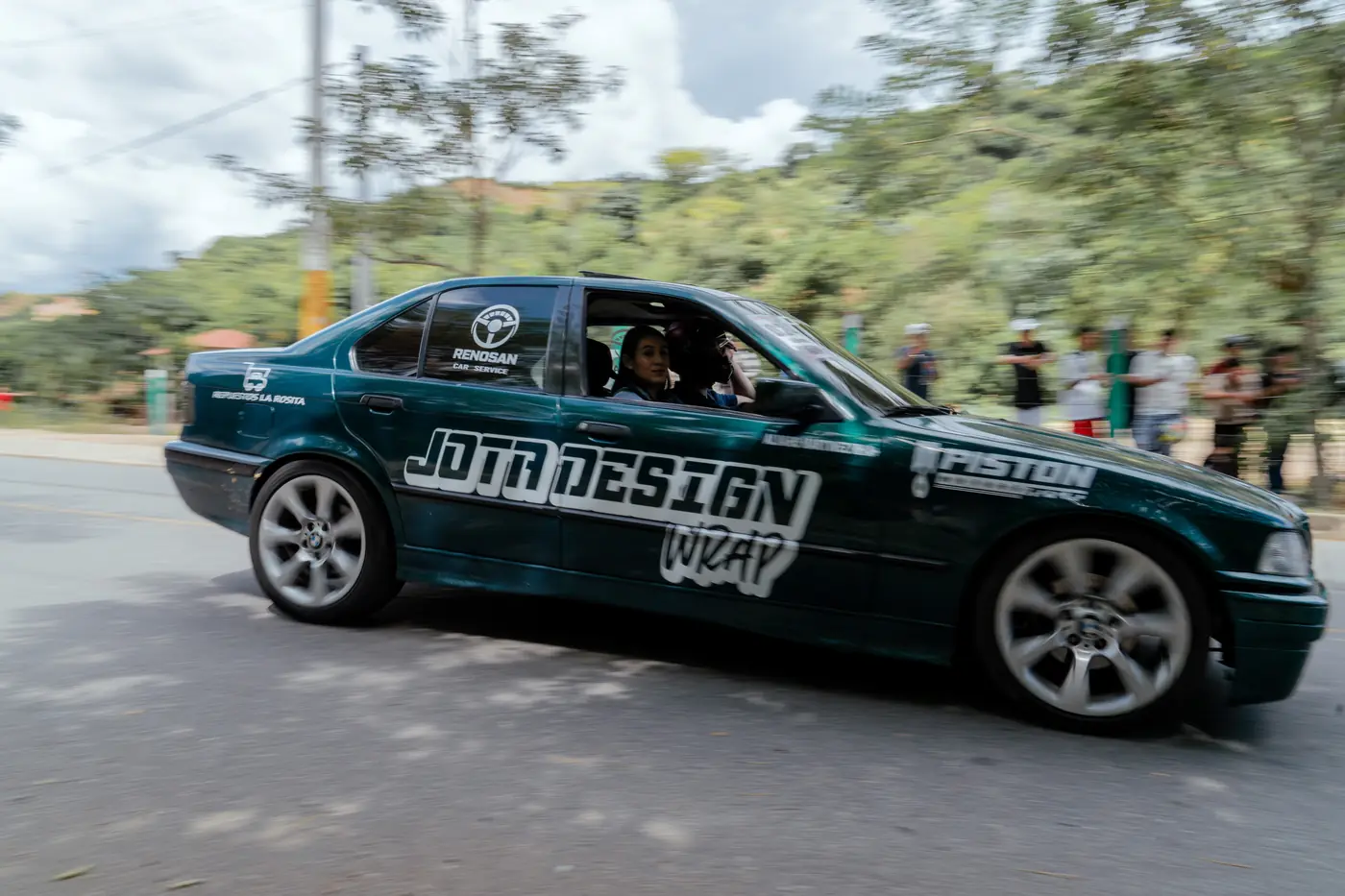BMW serie 3 verde oscuro de lado en la curva