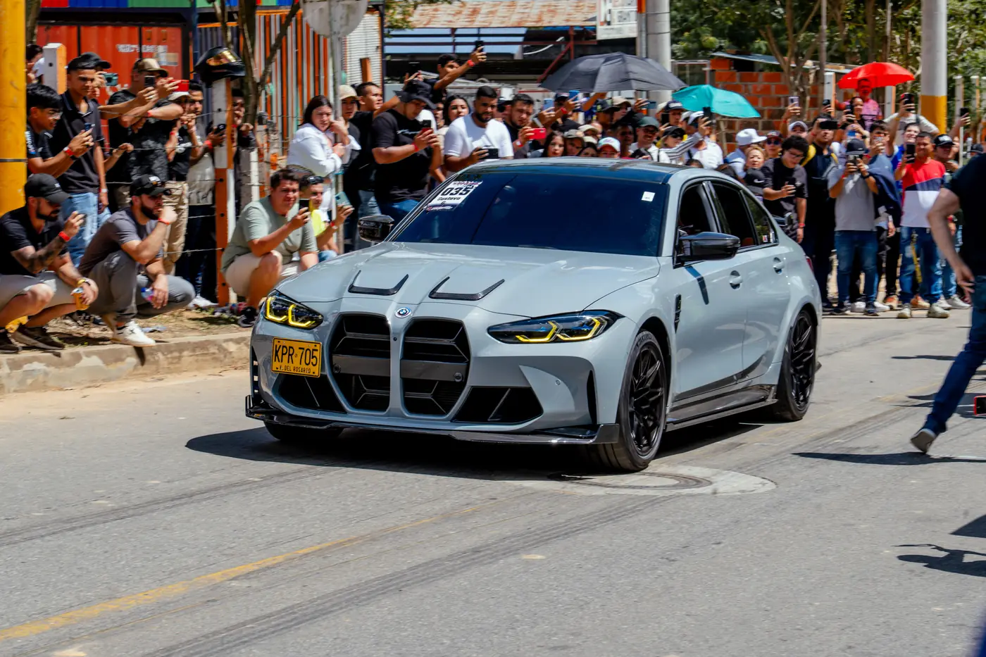 BMW M3 gris saliendo entre el público