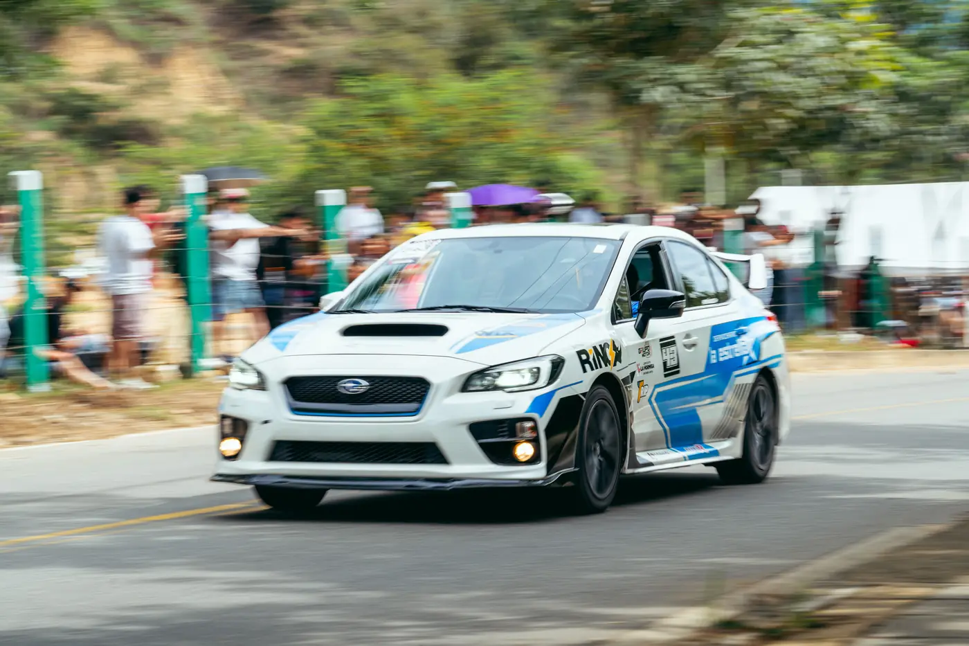 Subaru blanco y azul tomando la curva frente a la tribuna